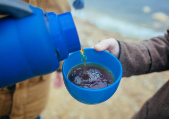 Man pouring tea at outdoors in autumn