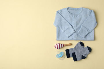 Flat lay composition with child's clothes and accessories on beige background, space for text