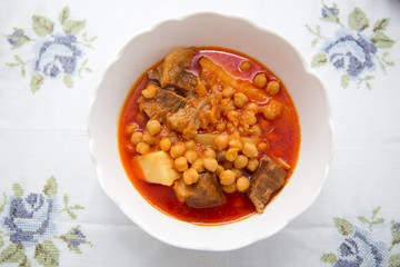 Kufta bozbash Middle Eastern mutton soup . Bowl of Bozbash - delicious Azerbaijan national soup on the table with white flowers .