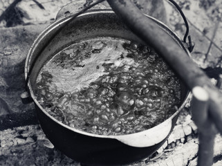 Ukrainian traditional soup cooking in old sooty cauldron