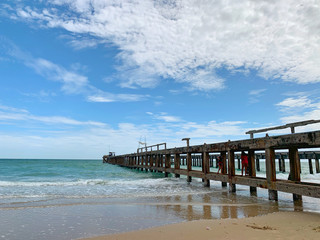 Fototapeta na wymiar Nature landscape. Amazing sandy tropical beach with bridge and tree in crystal clear sea and scenery wooden bridge out of the horizon / Palm and tropical beach.Close up.