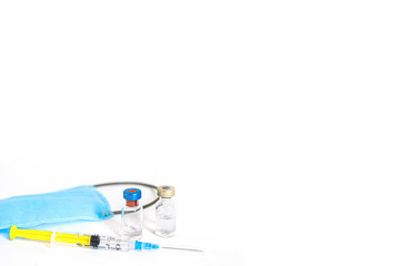 Syringe with vaccine and ampule and medical face mask on white