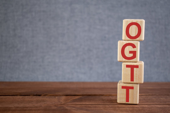 Abbreviation OGTT (oral Glucose Tolerance Test) Text Acronym On Wooden Cubes On Dark Wooden Backround. Medicine Concept.