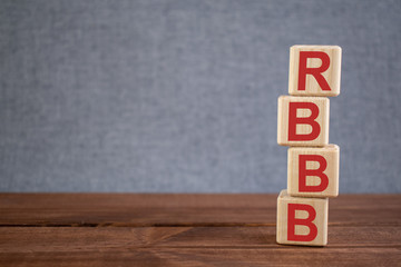 Abbreviation RBBB (right bundle branch block) text acronym on wooden cubes on dark wooden backround. Medicine concept.