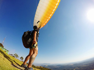 man on mountain top, standing with extreme paraglider. Brazil