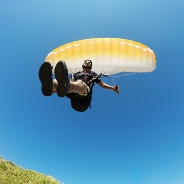 extreme paraglider flying in blue sky, freedom concept