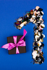 Festive composition with number 1 from color sequins and gift box. Greeting card mock up. Top view