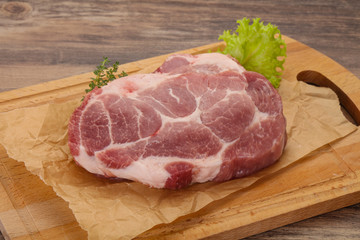 Raw pork steak over wooden board