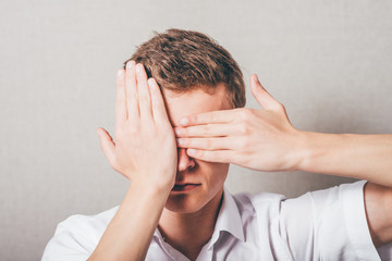 Fototapeta premium young man closes his eyes with his hands
