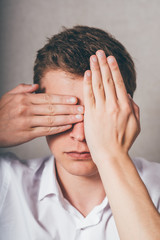 Fototapeta premium young man closes his eyes with his hands