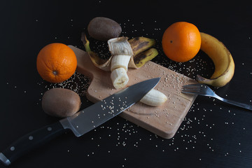 Preparando ensalada de frutas con kiwi, platano y naranja