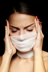 Beautiful woman with bandage mask on face. Fashion eye make-up. Beauty surgery or protection hygiene in virus pandemic