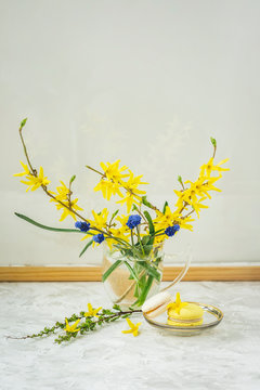 Bouquet of colorful near a glass wall in a wooden frame, slight reflection and two macaroons, romantic brackfest, bright morning