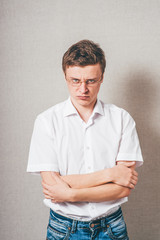 Man  in glasses hands crossed on his chest. On a gray background.