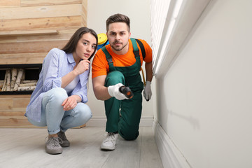 Woman showing insect traces to pest control worker at home