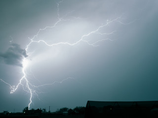 Bright lightning bolt strikes in the rural landscape of Transylvania, Romania