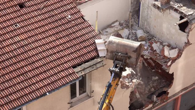 D&eacute;molition d'une habitation par un engin de chantier.