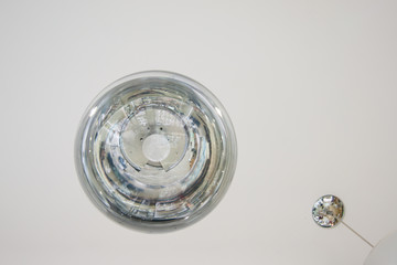 The interior design element of a huge store is the original form of transparent round glass ball-lamps of silver color.