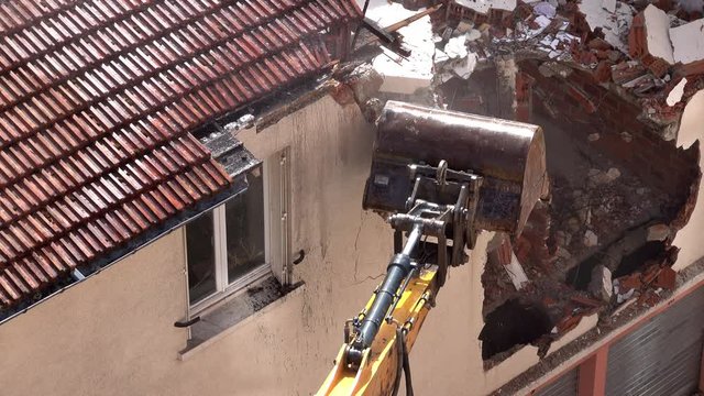 D&eacute;molition d'une habitation par un engin de chantier.