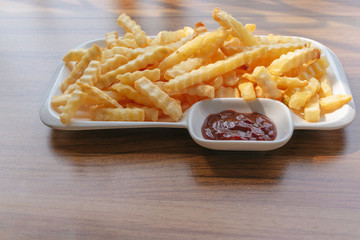 French fries on a plate, On the wood table background, Delicious and healthy because cooking in an oil-free frying pan, Selective focus.