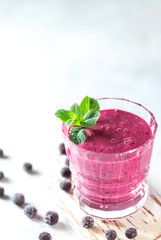 Vitamin smoothie from blackcurrant berries with yogurt and banana in a crystal glass. Healthy eating concept.