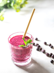 Vitamin smoothie from blackcurrant berries with yogurt and banana in a crystal glass. Healthy eating concept.