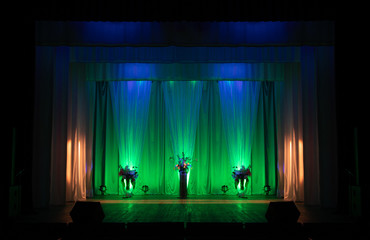 An empty stage of the theater, lit by spotlights before the performance