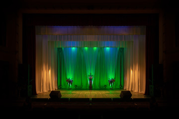 An empty stage of the theater, lit by spotlights before the performance