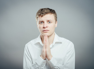 Young businessman praying. Isolated against white background.