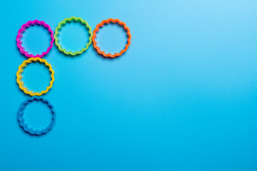 Five multi-colored plastic cookie cutter for making cookies on a blue background. Culinary concept....