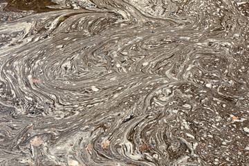 Surface of dirty  water puddle with white lines and shapes