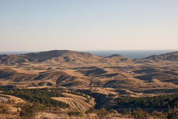 Fototapeta na wymiar green hills against the background of mountains