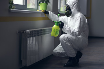 Cleaning and Disinfection at town complex amid the coronavirus epidemic. Professional teams for disinfection efforts. Infection prevention and control of epidemic. Protective suit and mask