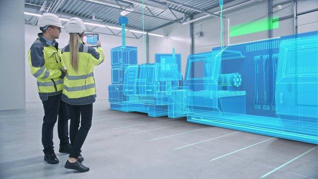 Two Engineers Use Digital Tablet Computer with Augmented Reality Software to Create 3D CNC Machinery, Equipment Visualization in Factory. Industry 4.0 Facility. VFX Special Visual Effect Graphics