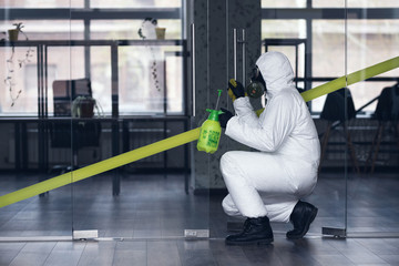 Obraz premium Cleaning and Disinfection at town complex amid the coronavirus epidemic. Professional teams for disinfection efforts. Infection prevention and control of epidemic. Protective suit and mask