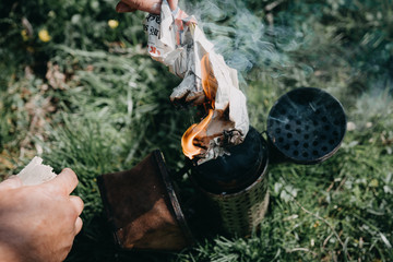 Chimney for flashing bees. Chimney stands near beehives.The beekeeper's tool. Bee smoker smoking.