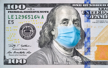 One hundred dollar bill with medical face mask on Benjamin Franklin.