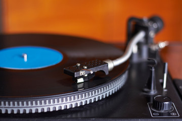 Extreme close-up of blue music record on turntable, turntable needle playing music, selective focus