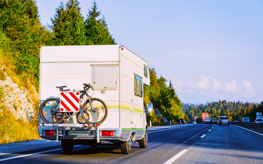 Camper rv and bicycle on road in Slovenia reflex