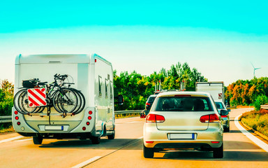 RV Camper with bicycles and car on Road in Switzerland reflex