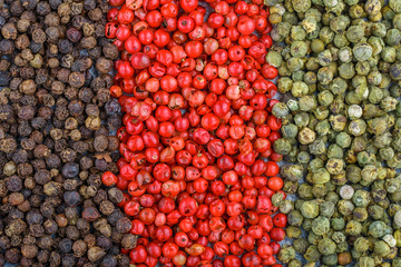 Pink, green and black pepper. Organic dried Peppercorns close-up. Spices and seasonings. Culinary background. Selective focus, top view