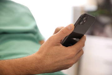 MYKOLAIV, UKRAINE - MARCH 16, 2020: Man holding iPhone 11 Black indoors, closeup