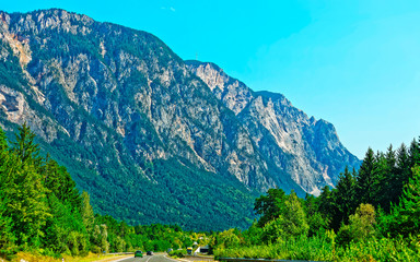 Road with cars and Alps mountains in Austria reflex