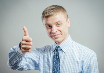 young man smiling and showing the thumbs up gesture