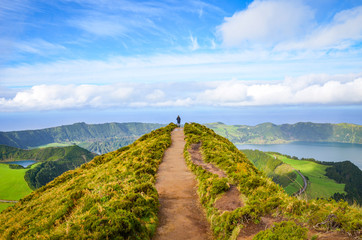 Plakat A path leading to viewpoint Miradouro da Boca do Inferno in Sao Miguel Island, Azores, Portugal. Amazing crater lakes surrounded by green fields and forests. Tourist at the end of the scenic way