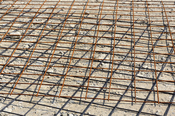 Background and texture of steel mats lying on the stony ground and partially rusted