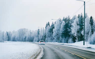 Car in a road in a snowy winter Lapland reflex