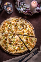Pizza with various cheese, walnuts and grapes