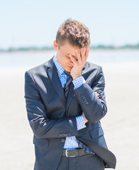 frustrated businessman on the beach