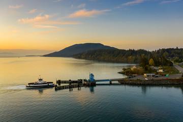 Aerial View of a Ferry Boat Landing at the Island Dock. Aerial shot of a small 21 car ferry landing at the Lummi Island ferry dock on a beautiful sunlit morning in the the Pacific Northwest, USA.